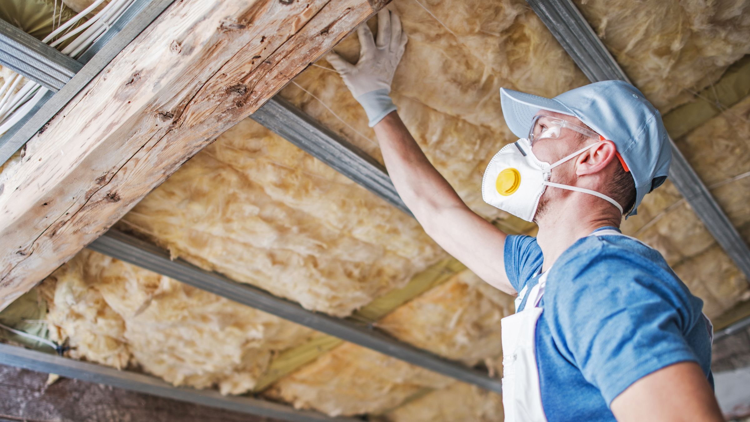 Attic framing and fiberglass insulation between joists, seen from inside the attic