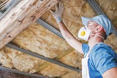 Attic framing and fiberglass insulation between joists, seen from inside the attic
