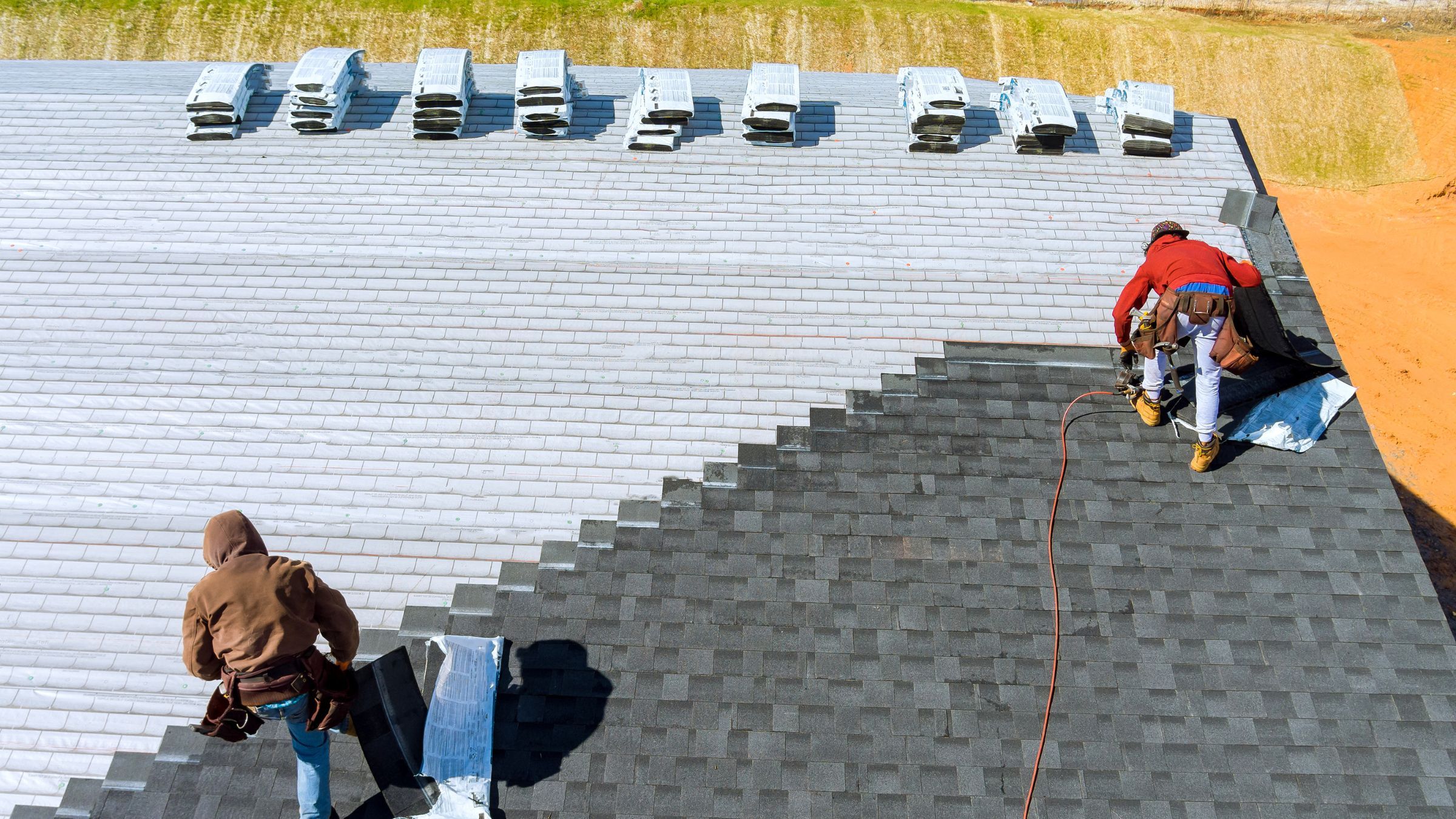 Roofing crew installing asphalt shingles on a residential roof