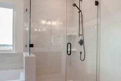 Frameless glass shower door with minimal hardware in a tiled bathroom