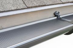 Micro-mesh gutter guard fastened along the edge of a shingled roof