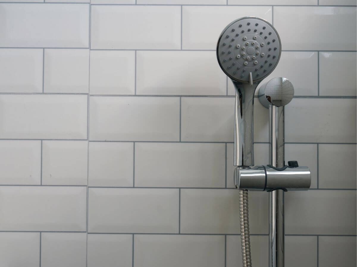 Handheld shower head mounted on a vertical slide bar