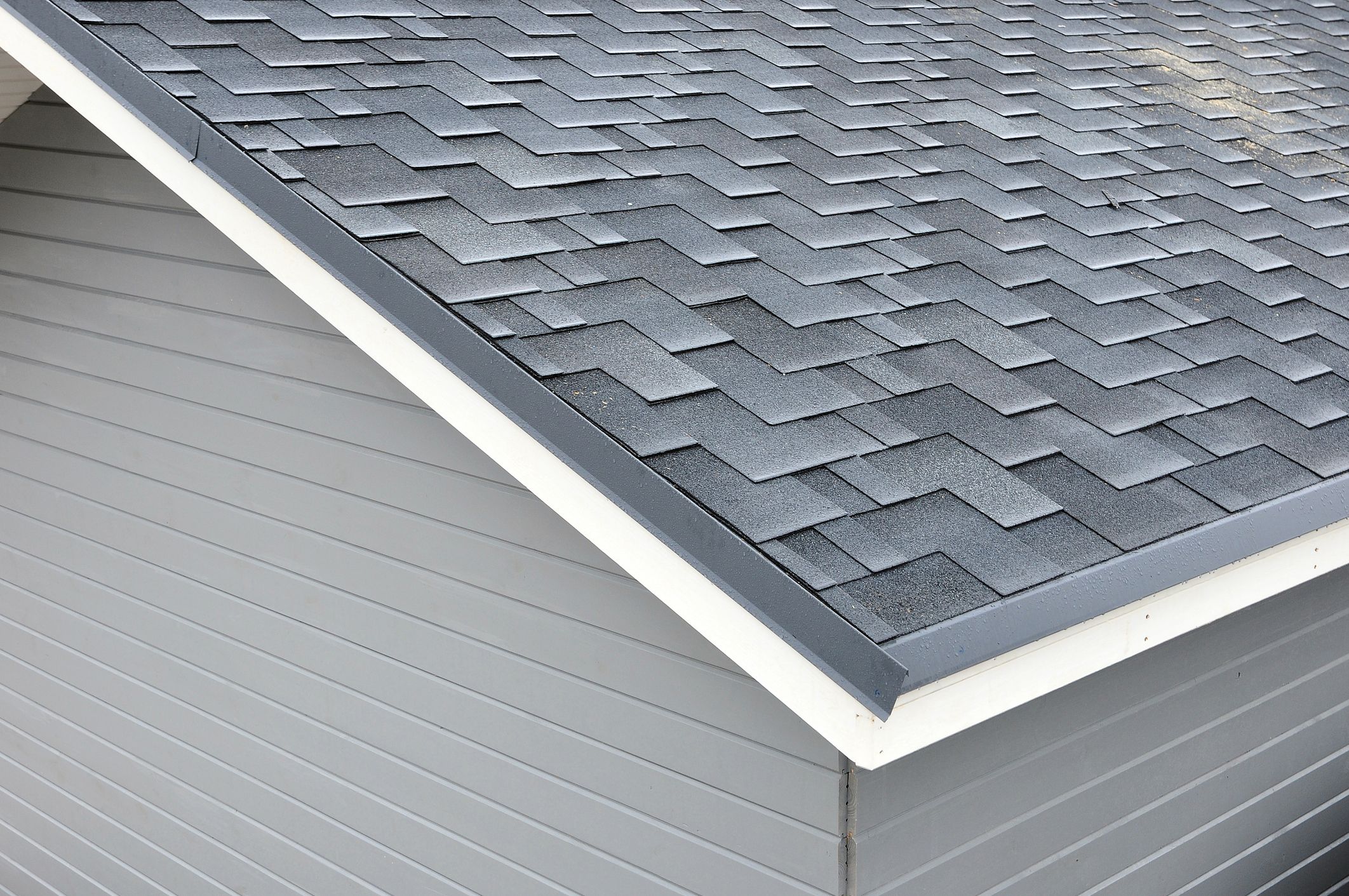 Architectural asphalt shingles showing layered shadow lines on a residential roof