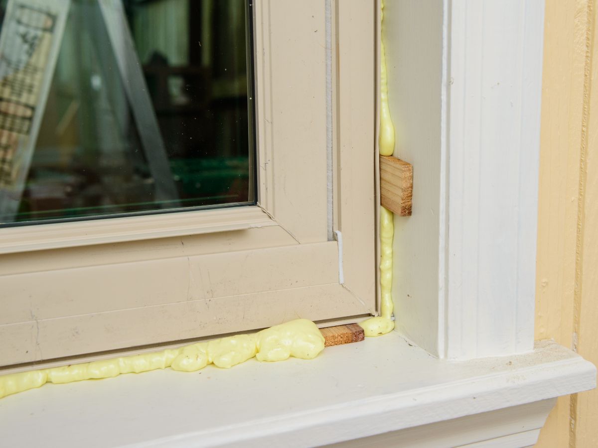 Expanding foam insulation sealing the gap between a window frame and the wall