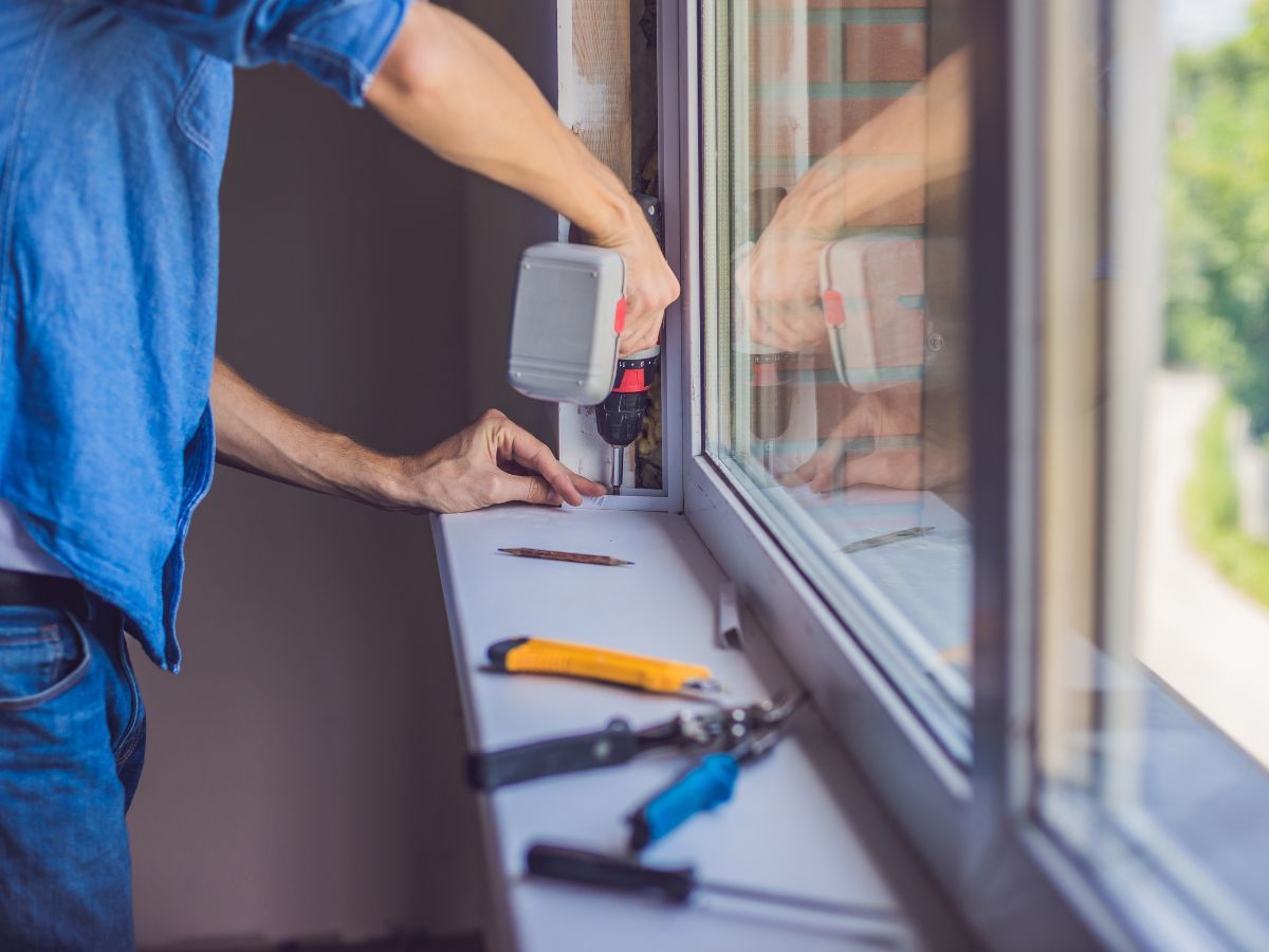 Installer fastening interior trim around a newly installed window