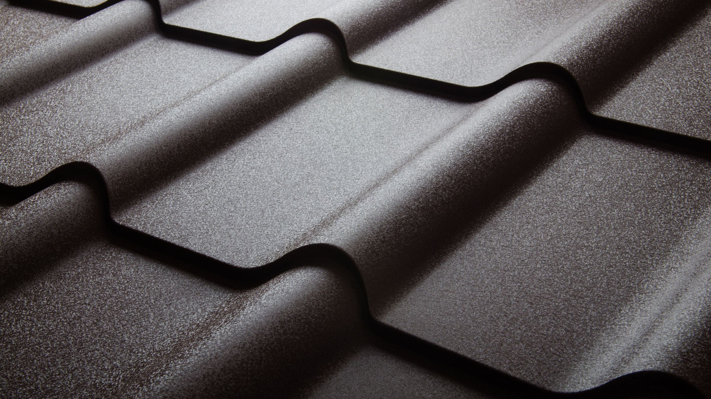 Stone-coated metal shingles laid to resemble traditional shingle courses