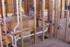 Open bathroom wall and floor showing plumbing rough-in during a remodel