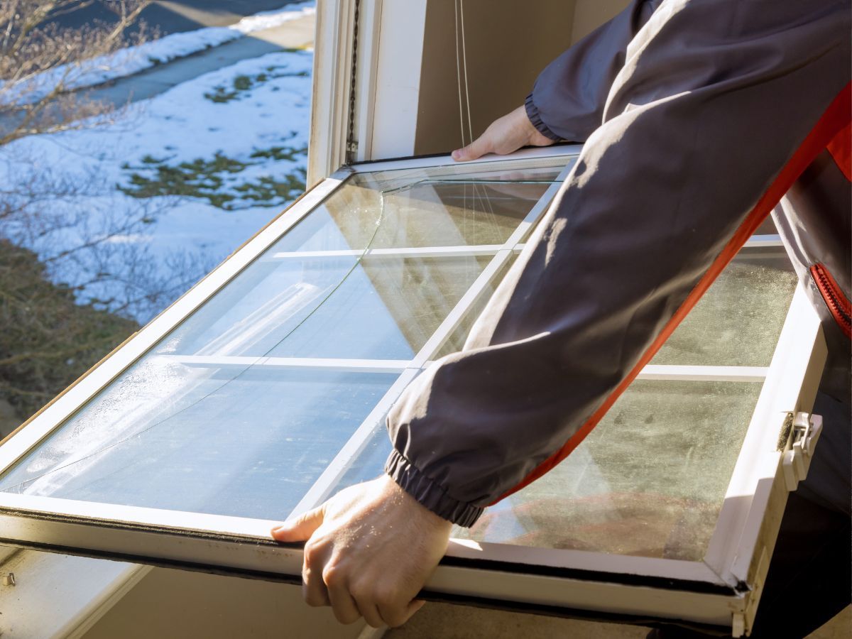 Installer removing an old window unit from its opening