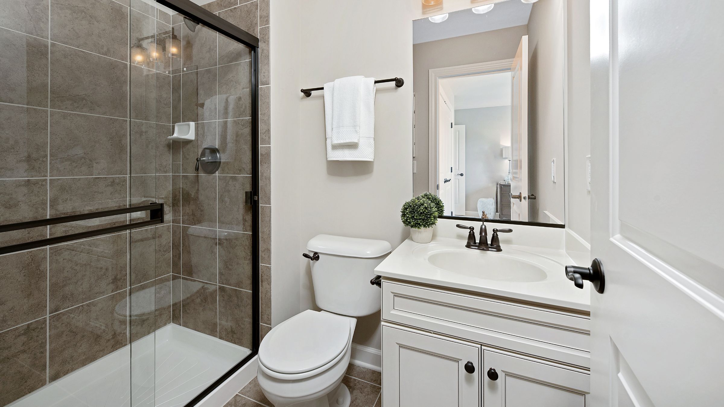 Simple tiled shower with a framed glass door in a small bathroom