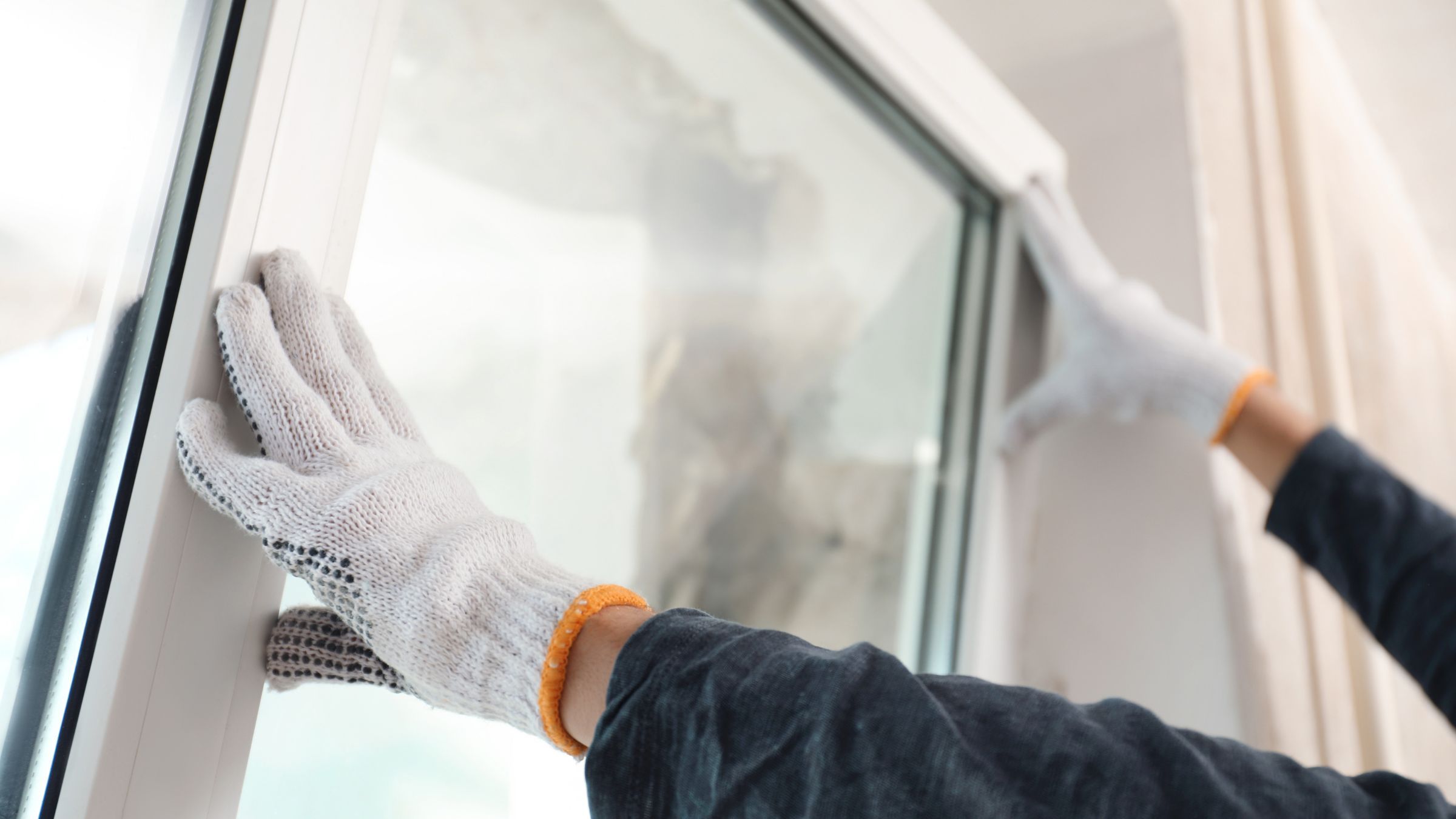 Installer setting a replacement window into a wall opening