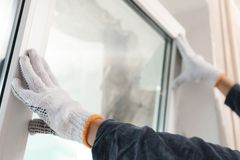 Installer setting a replacement window into a wall opening