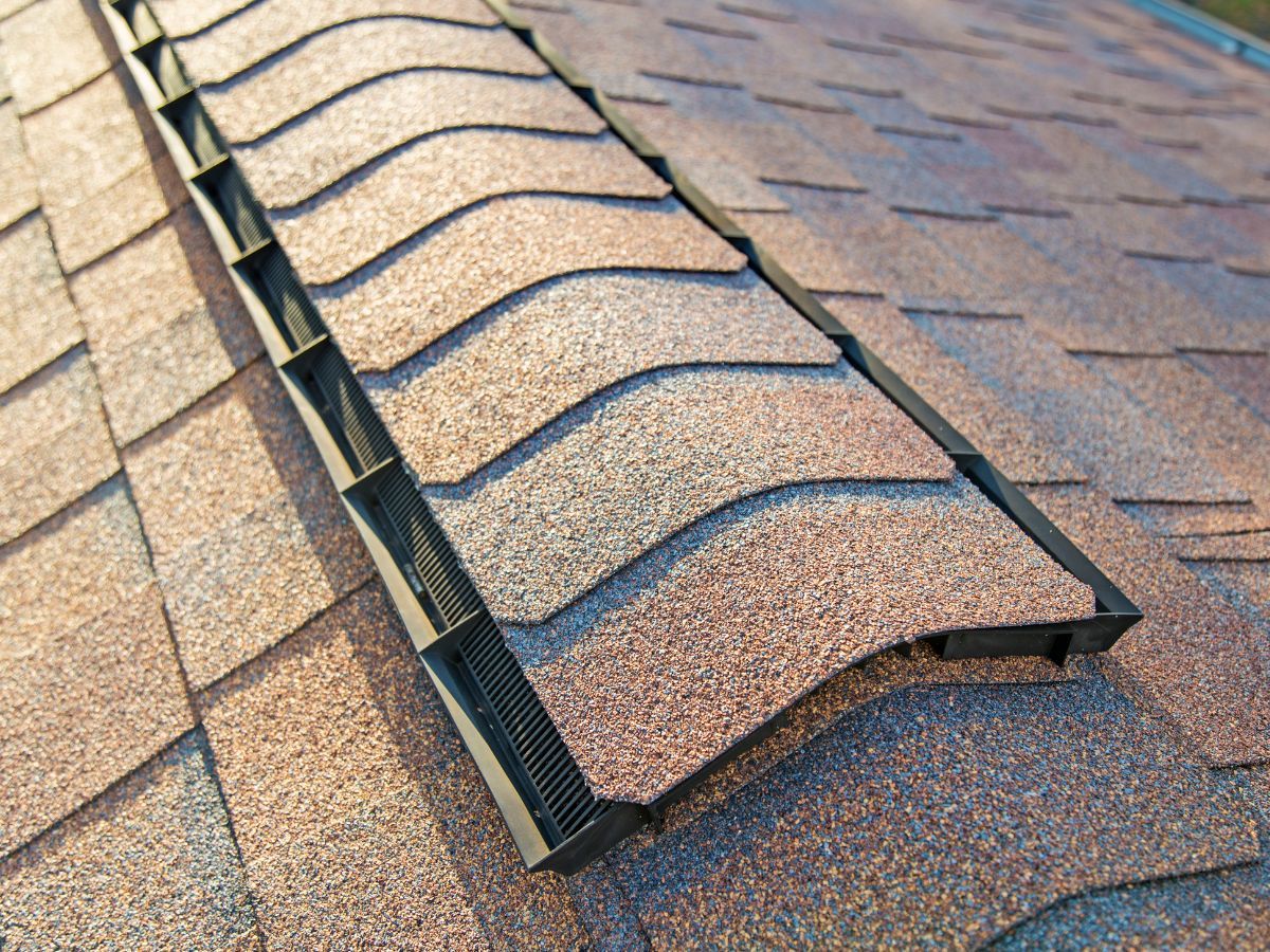 Shingle-over ridge vent running along the peak of an asphalt shingle roof