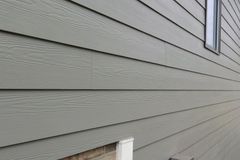 Fiber cement lap siding with visible woodgrain texture on a house wall
