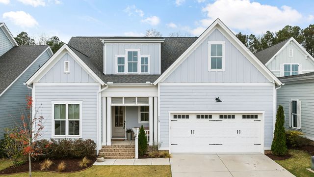 Two-story home with pale blue lap and board-and-batten siding, white trim and a two-car garage