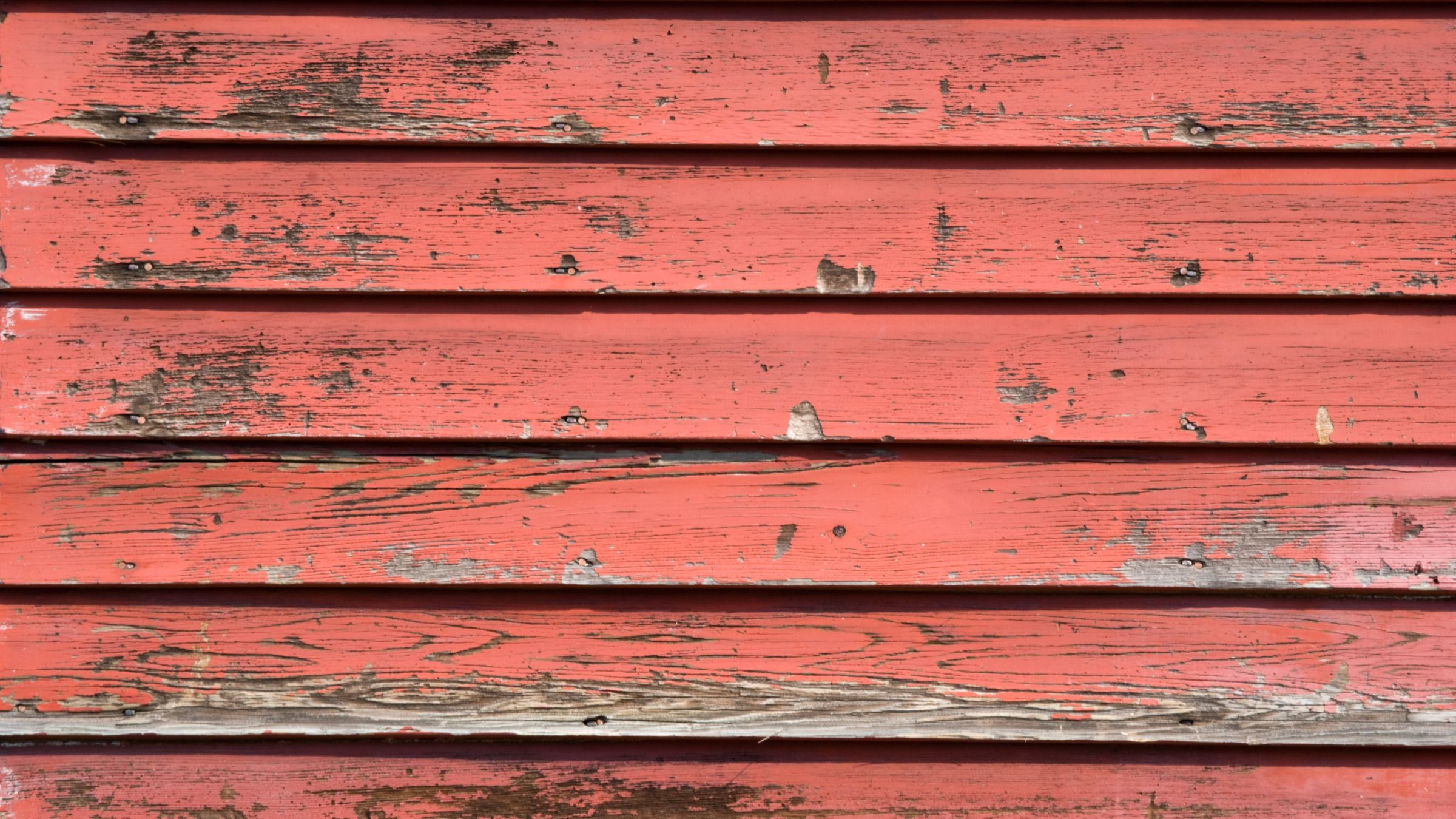 Aged lap siding on a house wall showing chalking and colour fade