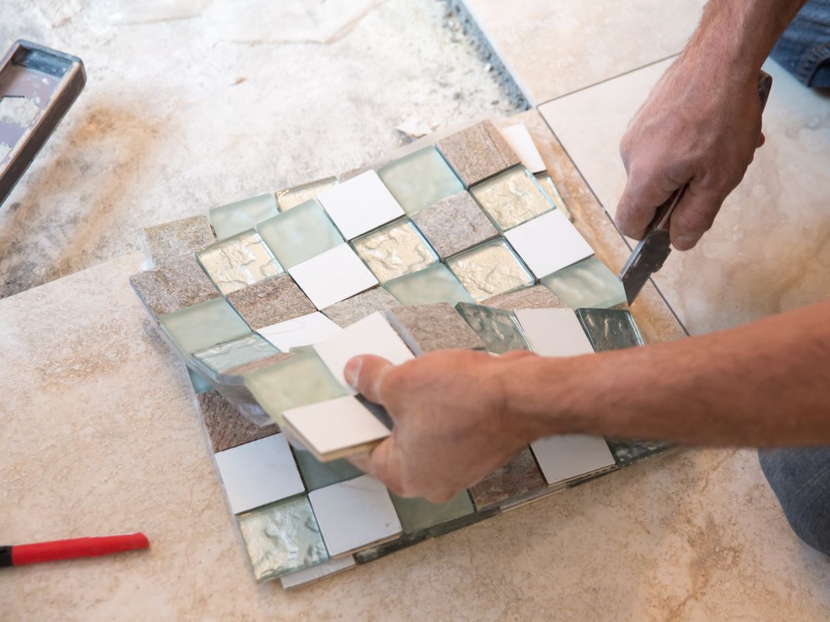 Installer cutting mosaic accent tile during a bathroom remodel