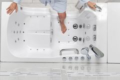 Walk-in tub with an integrated grab bar and handheld shower attachment